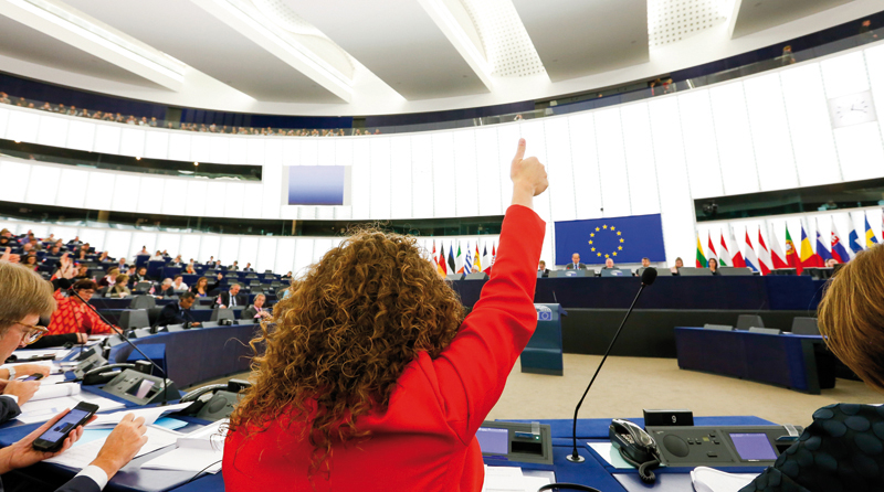 Μέλος του Ευρωπαϊκού Κοινοβουλίου σηκώνει το χέρι της κατά τη διάρκεια συνεδρίασης.